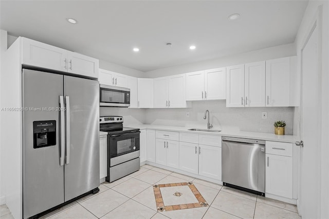 kitchen featuring sink, white cabinets, light tile patterned flooring, and appliances with stainless steel finishes