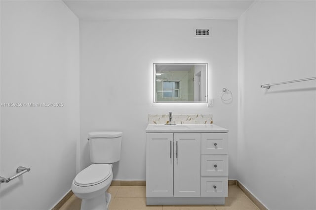 bathroom with toilet, tile patterned flooring, and vanity