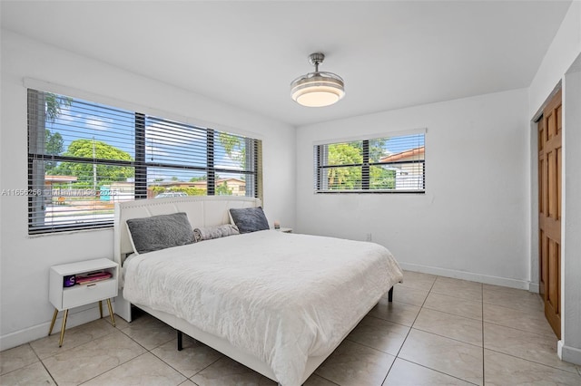 bedroom with light tile patterned floors and multiple windows