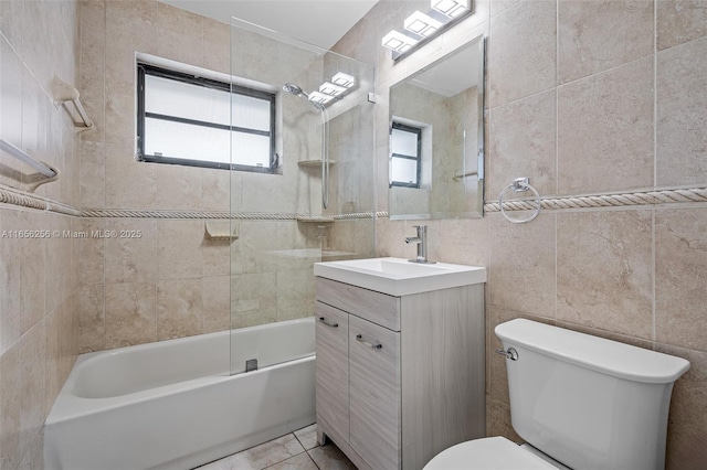 full bathroom with toilet, tile walls, tile patterned floors, tiled shower / bath, and vanity