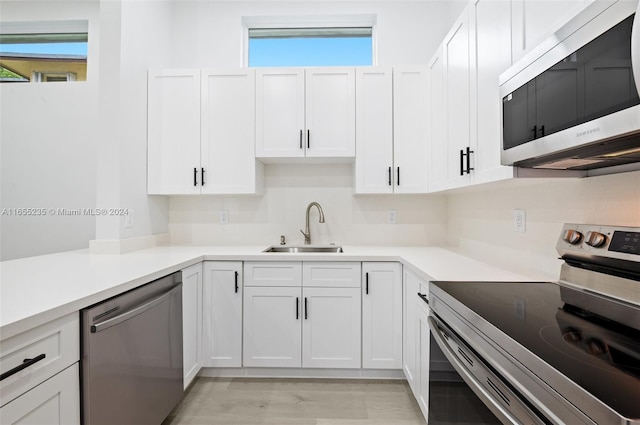 kitchen featuring light hardwood / wood-style floors, sink, white cabinetry, and stainless steel appliances