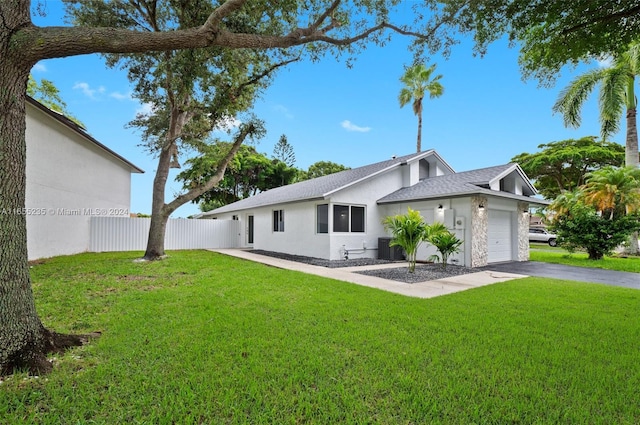 rear view of property featuring a garage and a yard