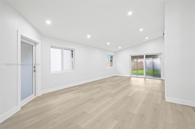 unfurnished room featuring light hardwood / wood-style flooring and lofted ceiling