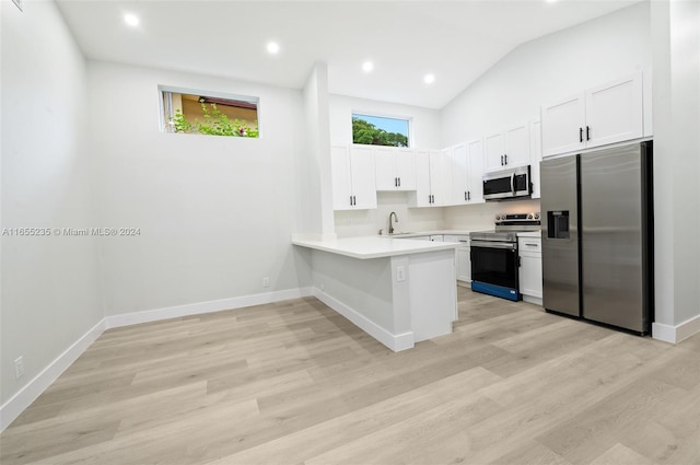 kitchen featuring kitchen peninsula, stainless steel appliances, white cabinetry, and light hardwood / wood-style floors