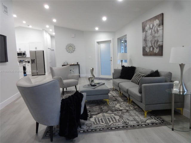 living room featuring lofted ceiling and light wood-type flooring