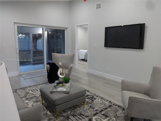 living room with wood-type flooring and a high ceiling