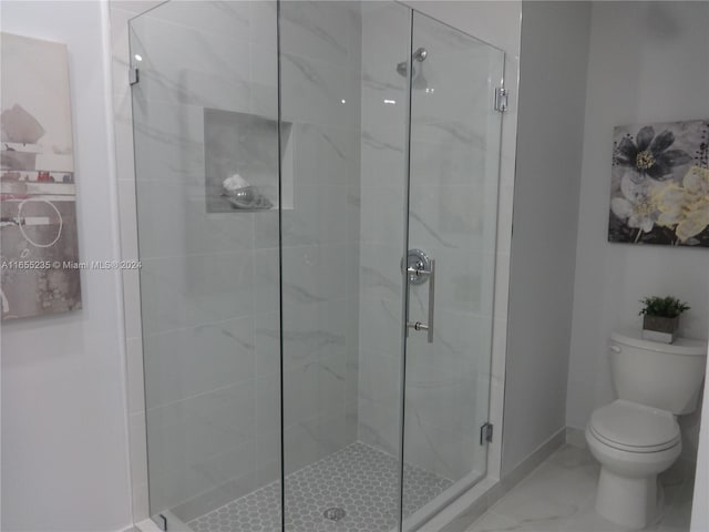 bathroom with toilet and a shower with door