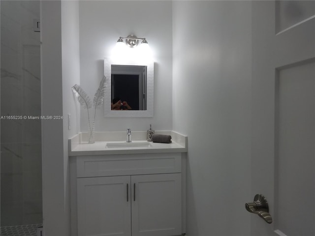 bathroom featuring a tile shower and vanity