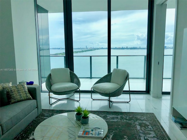 living room featuring a water view, floor to ceiling windows, and plenty of natural light