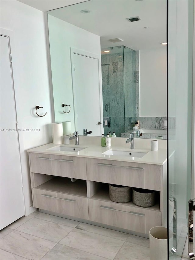 bathroom with a shower with door and vanity