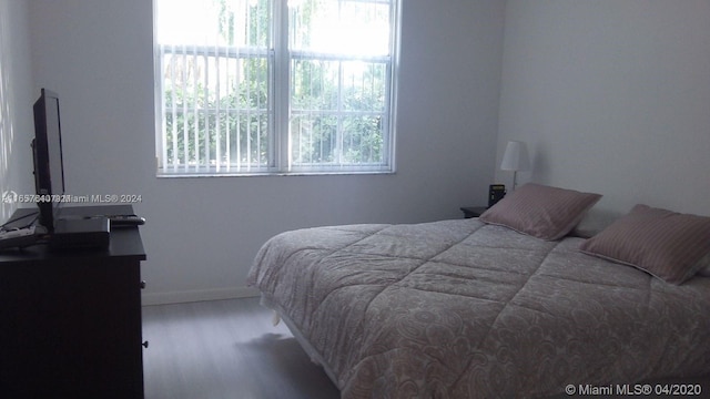 bedroom featuring multiple windows and hardwood / wood-style flooring