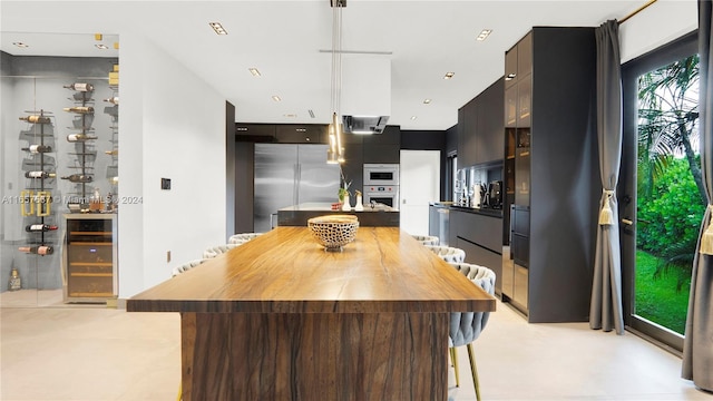 kitchen featuring beverage cooler, a kitchen island, and stainless steel appliances