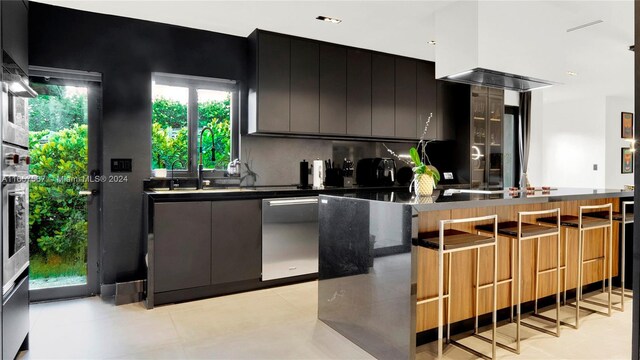 kitchen with dark stone countertops, kitchen peninsula, dishwasher, and decorative backsplash