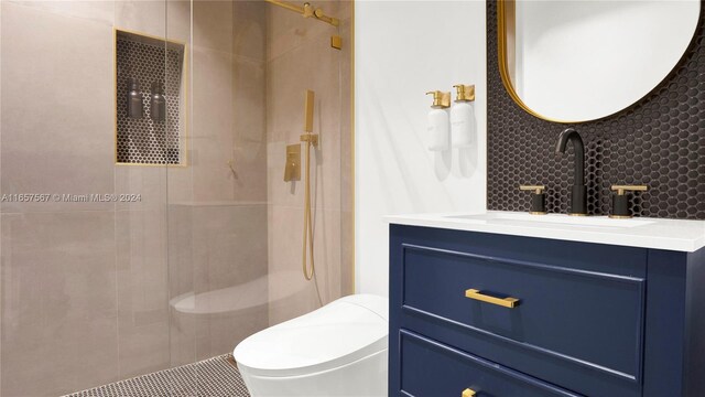 bathroom featuring vanity, toilet, and a tile shower