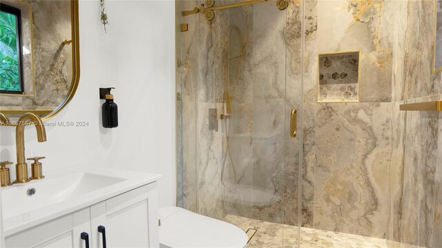 bathroom featuring toilet, an enclosed shower, and vanity