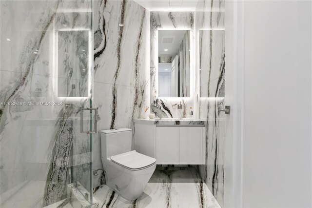 bathroom with vanity, toilet, an enclosed shower, and tile walls