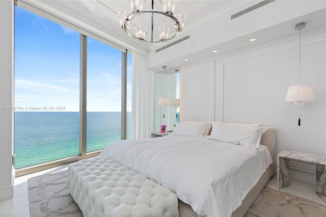 bedroom featuring an inviting chandelier, multiple windows, and a water view