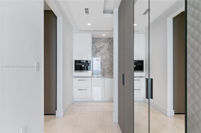 hall with light tile patterned floors