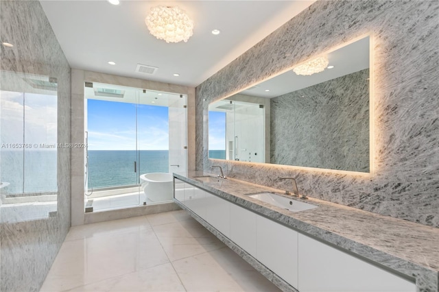 bathroom with vanity, a bathing tub, tile patterned floors, a chandelier, and a water view