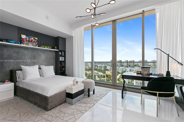 bedroom featuring a water view, a wall of windows, and a notable chandelier