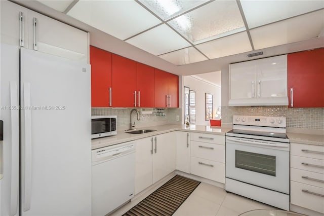 kitchen featuring white appliances, white cabinetry, sink, backsplash, and light tile patterned flooring