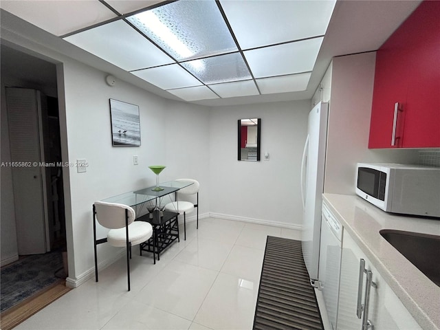 kitchen with light tile patterned floors, sink, and white appliances