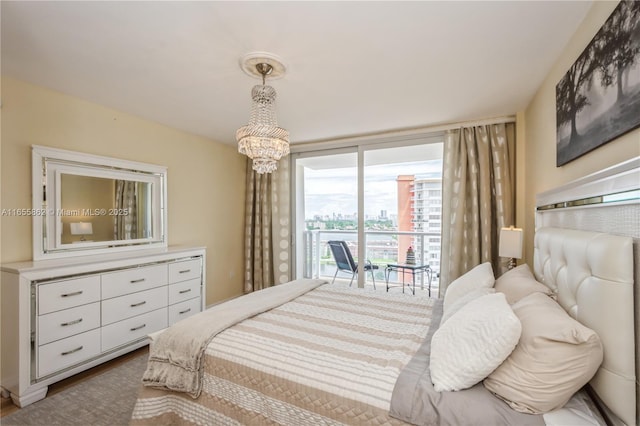 bedroom featuring an inviting chandelier and access to exterior