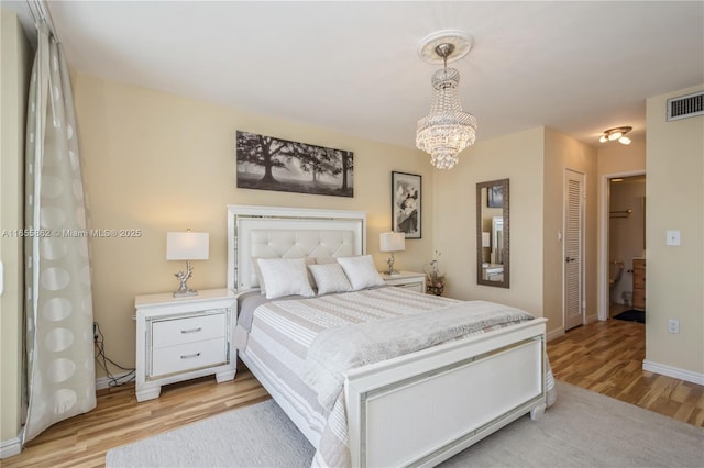 bedroom featuring a closet, light hardwood / wood-style flooring, and an inviting chandelier