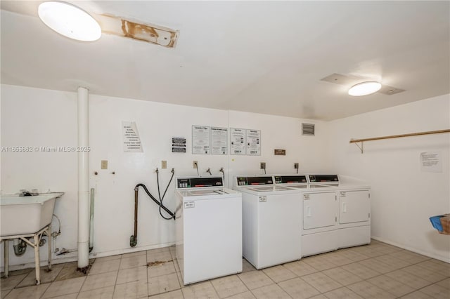 laundry area with sink and washing machine and clothes dryer