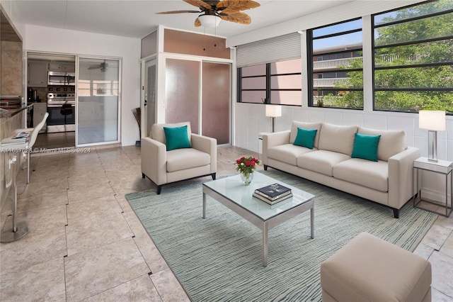 living room with ceiling fan and tile walls