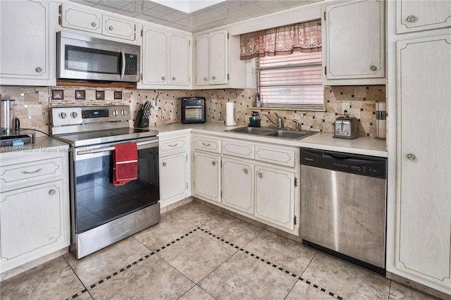 kitchen with white cabinetry, sink, appliances with stainless steel finishes, and tasteful backsplash