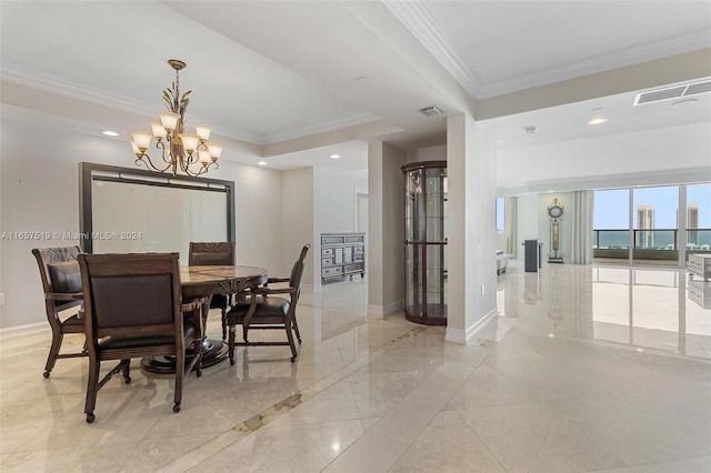 dining space with ornamental molding, an inviting chandelier, and a tray ceiling