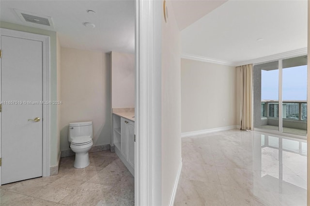 bathroom with crown molding, vanity, and toilet