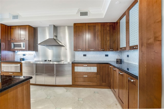 kitchen featuring wall chimney exhaust hood, decorative backsplash, light tile patterned flooring, and ornamental molding