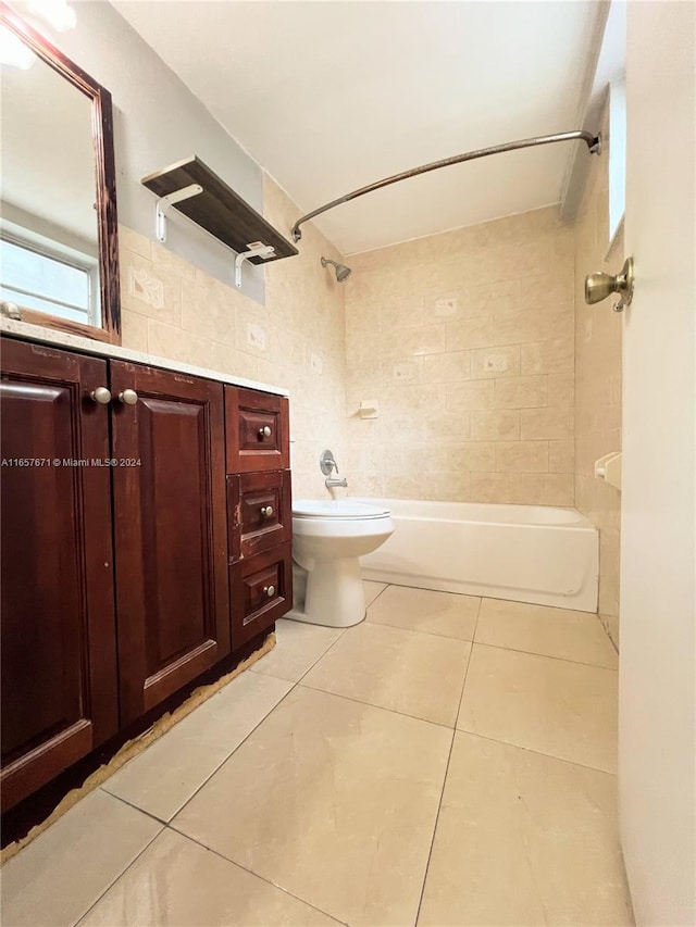 full bathroom featuring tiled shower / bath, tile walls, toilet, and tile patterned floors