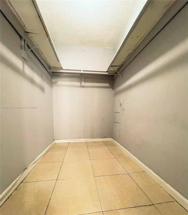 walk in closet with light tile patterned flooring