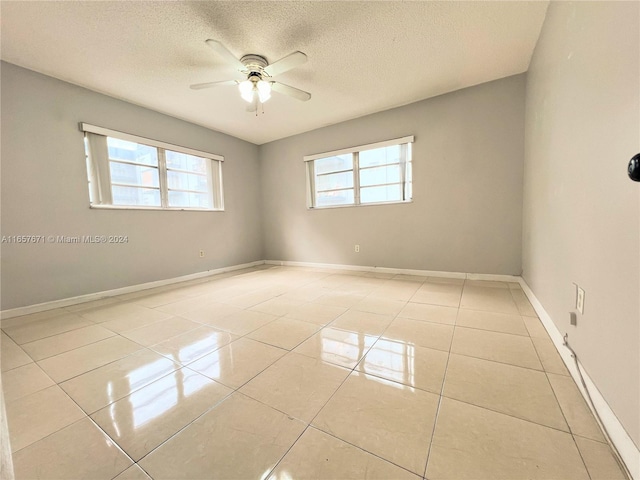 unfurnished room featuring ceiling fan, a textured ceiling, and light tile patterned flooring