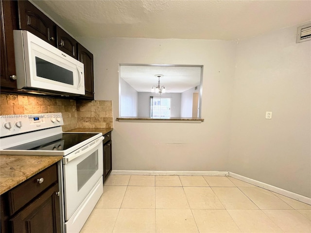 kitchen with dark brown cabinets, backsplash, a chandelier, and white appliances