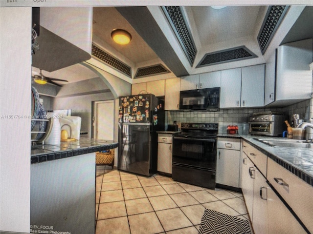 kitchen featuring sink, black appliances, tasteful backsplash, light tile patterned floors, and ceiling fan