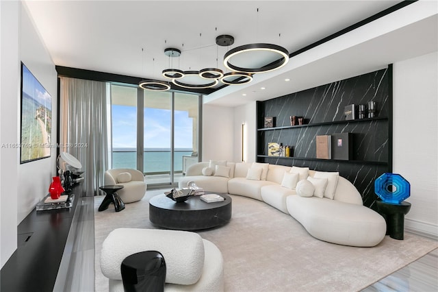 living room with a notable chandelier, floor to ceiling windows, and hardwood / wood-style flooring