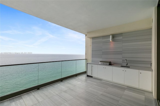 balcony featuring a water view and sink