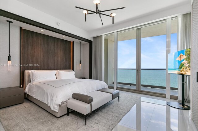 bedroom with light tile patterned floors, a notable chandelier, access to exterior, and a water view