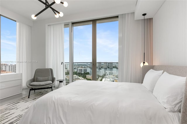 bedroom with a water view and an inviting chandelier