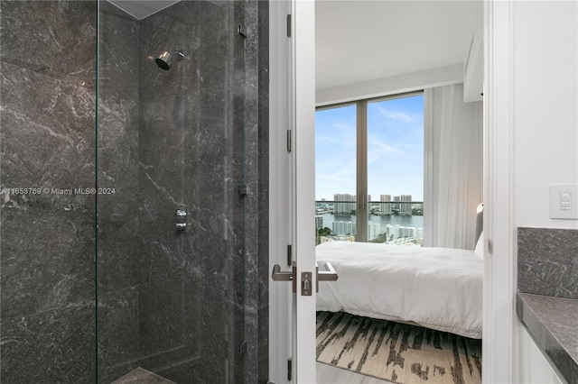 bathroom featuring a water view, hardwood / wood-style flooring, and tiled shower