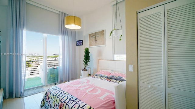 bedroom featuring light tile patterned floors, a closet, and access to exterior