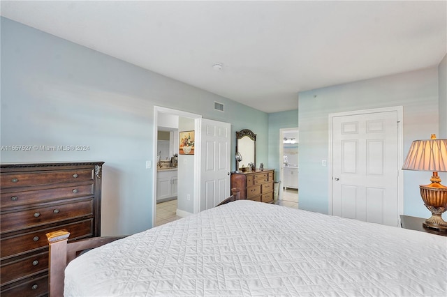 bedroom with light tile patterned floors and ensuite bathroom