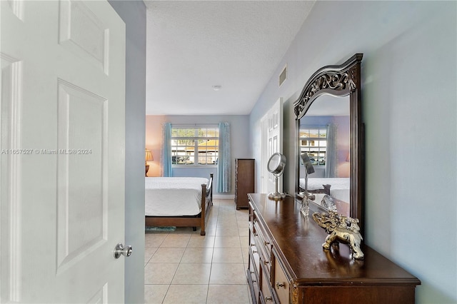 bedroom with a textured ceiling and light tile patterned flooring