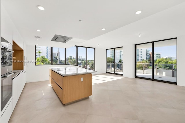 kitchen featuring recessed lighting, oven, a city view, and modern cabinets