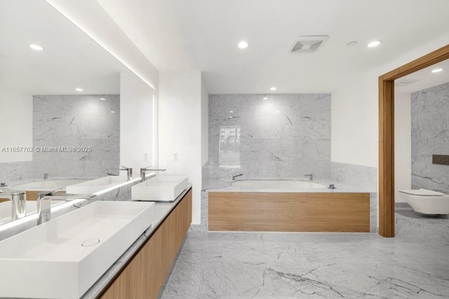 full bath featuring marble finish floor, double vanity, a sink, and recessed lighting