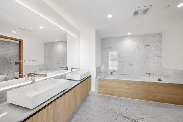 kitchen featuring a healthy amount of sunlight, white cabinets, a kitchen island, and sink